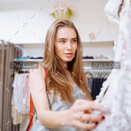 woman-doing-shopping-and-choosing-clothes-in-PDEP6XU